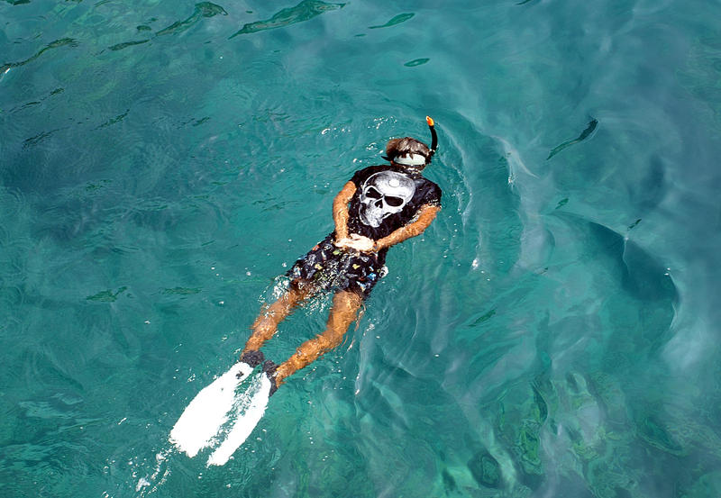 Kille snorklar i korallrev i Thailand