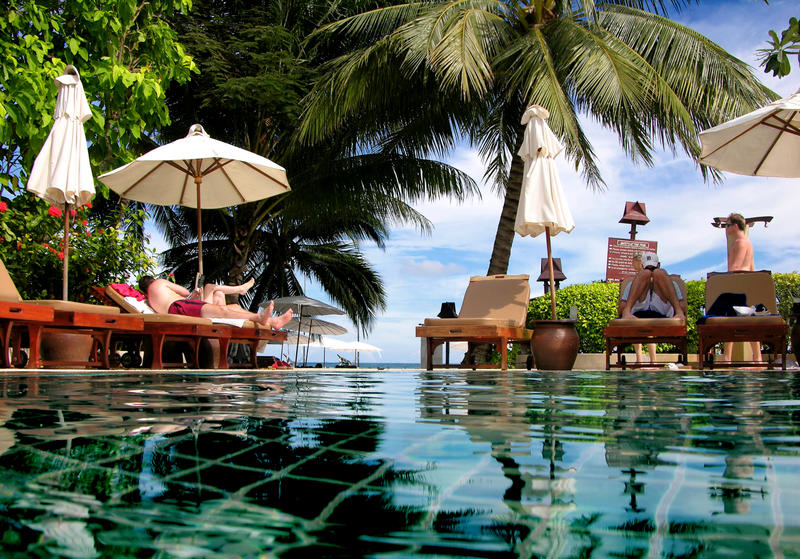 Turister slappar vid pool i Thailand