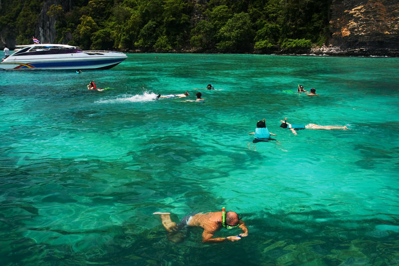 Turister snorklar i Thailand